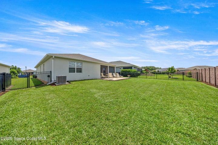 Expansive green lawn with a concrete patio area