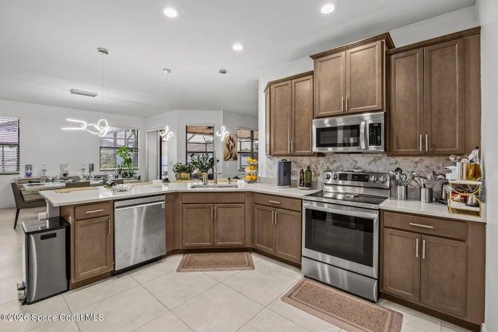 The heart of the home, this thoughtfully designed kitchen features timeless cabinetry, quartz countertops, stainless steel appliances, abundant workspace, and an oversized island that keeps everyone connected while cooking, dining, or entertaining.