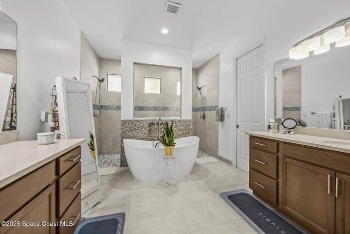 Designed for both beauty and function, the spacious primary bath offers dual vanities, a freestanding soaking tub, and two walk-in showers—creating a comfortable space for busy mornings and relaxing evenings.