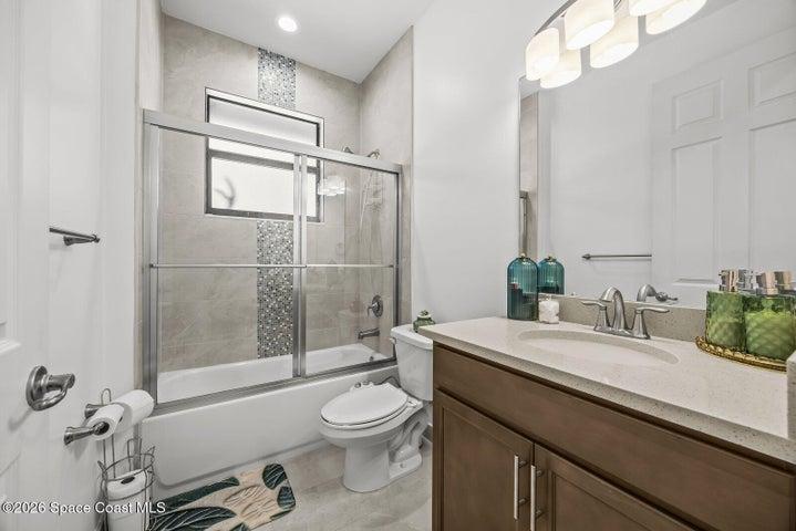Conveniently appointed with a quartz vanity, tiled tub and shower combination, and contemporary finishes, this full bath is ideal for family, guests, or everyday use.