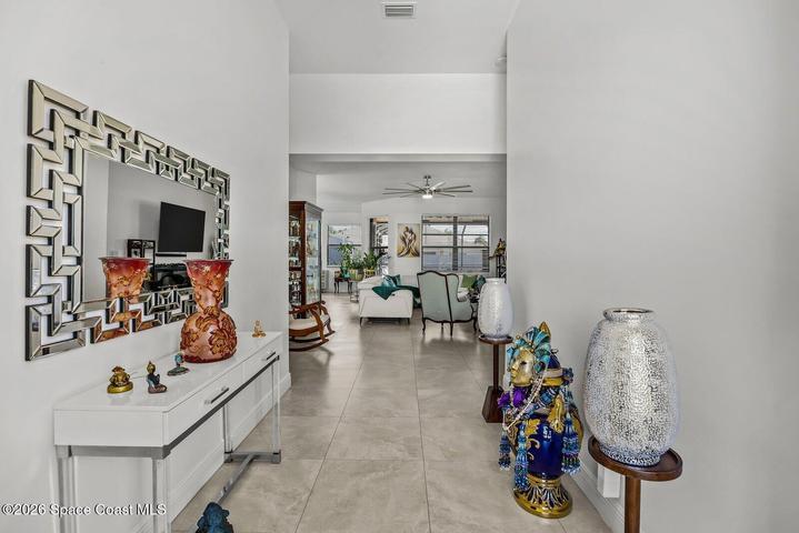 A bright, inviting foyer with soaring ceilings creates a memorable first impression and offers a clear sightline into the heart of the home.