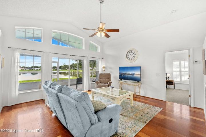 Featuring wood flooring, vaulted ceiling and floor to ceiling wall of windows