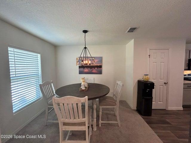 Dedicated dining space featuring a contemporary chandelier, and neutral wall tones.