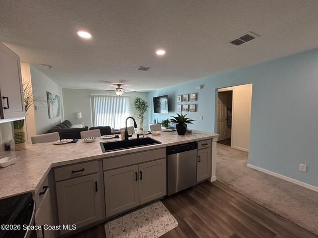Large Kitchen featuring vinyl plank flooring, goose neck faucet, black sink.