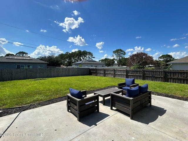 Expansive green lawn with a full privacy fence