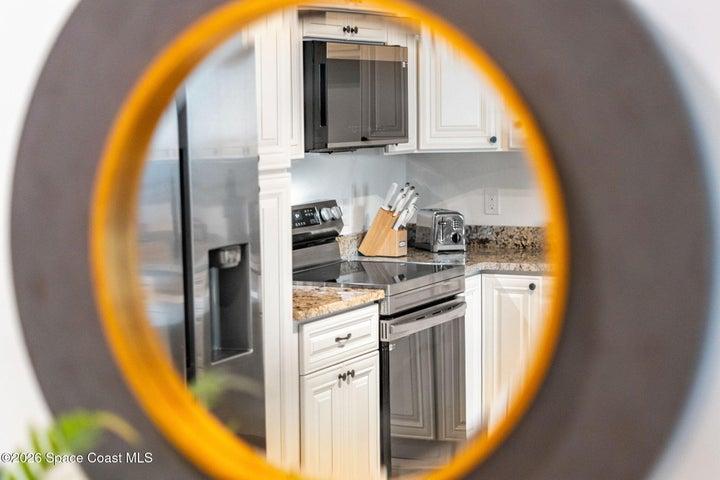 The modern kitchen combines solid wood cabinetry, granite surfaces and under-cabinet lighting in a clean, functional design.