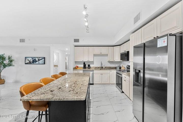 The modern kitchen combines solid wood cabinetry, granite surfaces and under-cabinet lighting in a clean, functional design.