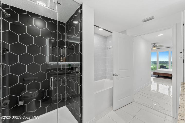 A frameless glass shower complements the primary bathroom’s clean lines and modern architectural design.