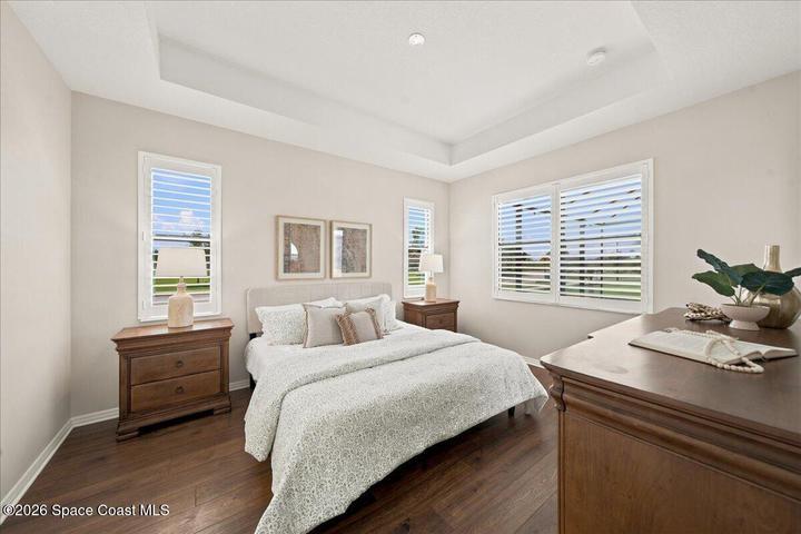 Beautiful freshly painted primary bedroom with wood floors.