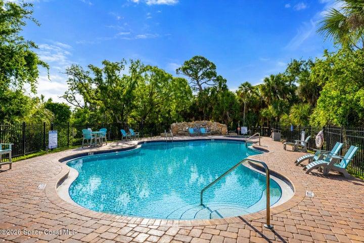 The heated resort-style pool and waterfall feature create a private escape within the River Fly-In community.