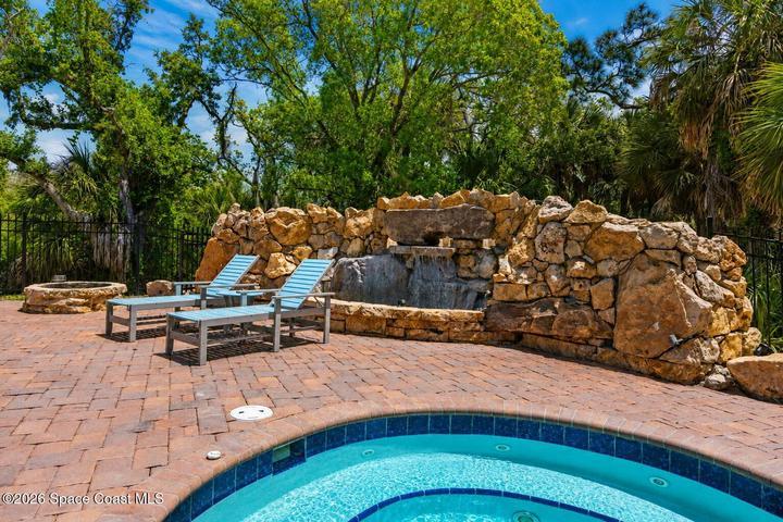 The heated resort-style pool and waterfall feature create a private escape within the River Fly-In community.