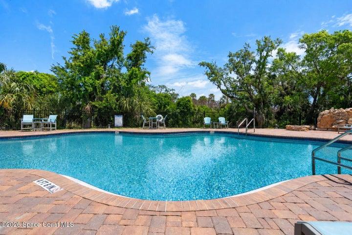 The heated resort-style pool and waterfall feature create a private escape within the River Fly-In community.