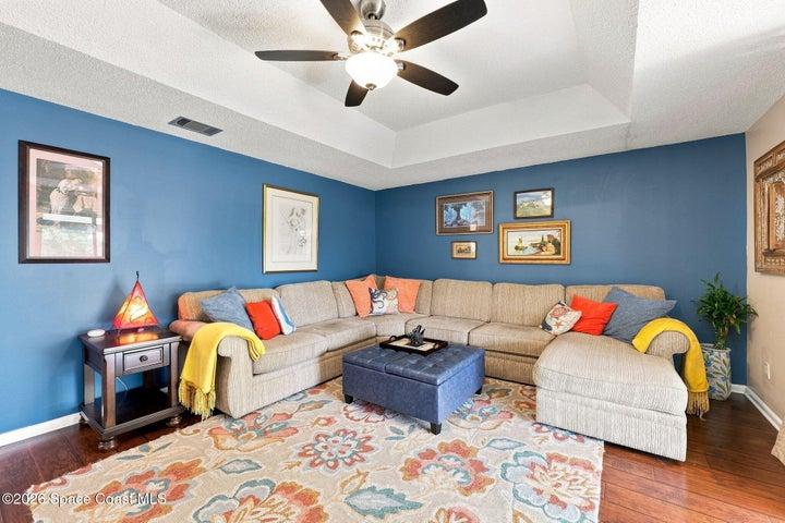 The open living room flows seamlessly into a spacious flex space and extends to the screened-in lanai, creating an inviting layout for relaxing and entertaining.