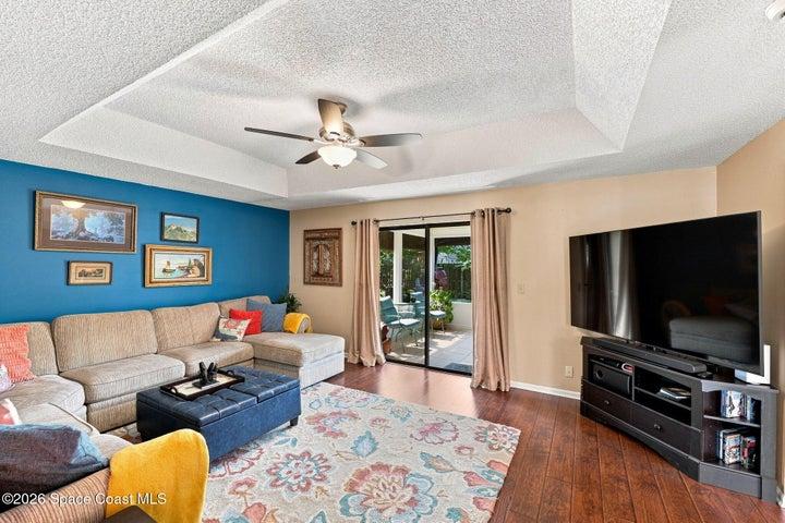 The open living room flows seamlessly into a spacious flex space and extends to the screened-in lanai, creating an inviting layout for relaxing and entertaining.