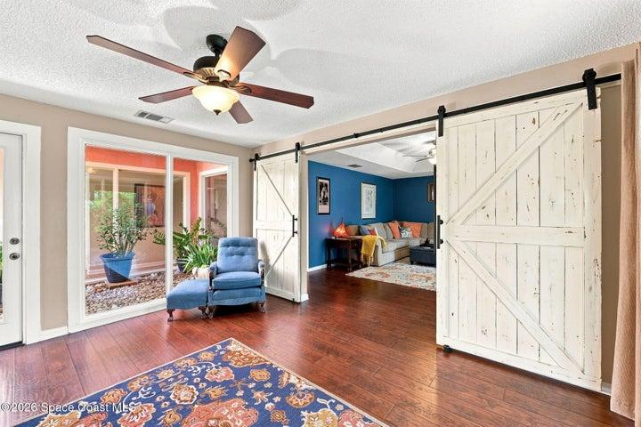 Versatile flex space with direct access to both the screened-in lanai and the central atrium, creating a bright and inviting connection to the outdoors.