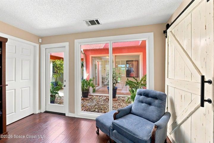 Versatile flex space with direct access to both the screened-in lanai and the central atrium, creating a bright and inviting connection to the outdoors.