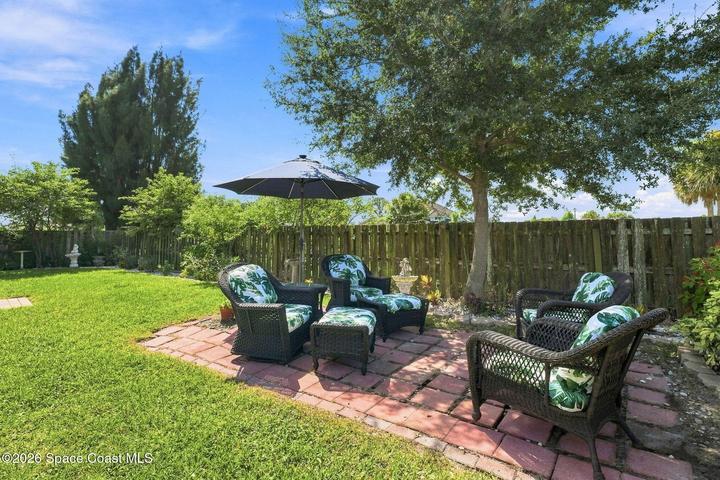 Well-maintained, fully fenced backyard featuring lush landscaping and an abundance of mature plants, creating a private and inviting outdoor retreat.