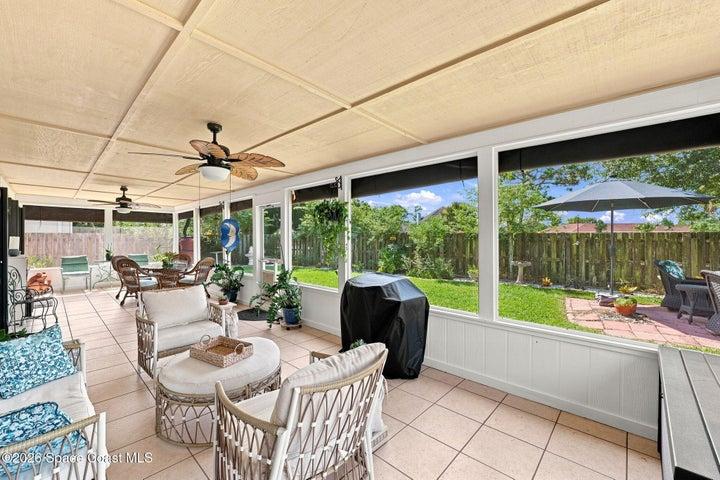 Spacious screened-in lanai with ceiling fans and multiple access points from the living room, flex space, and primary bedroom—perfect for relaxing or entertaining.