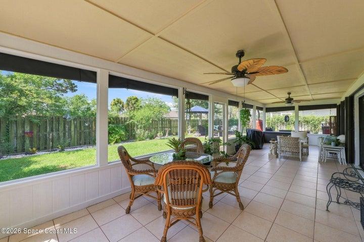Spacious screened-in lanai with ceiling fans and multiple access points from the living room, flex space, and primary bedroom—perfect for relaxing or entertaining.