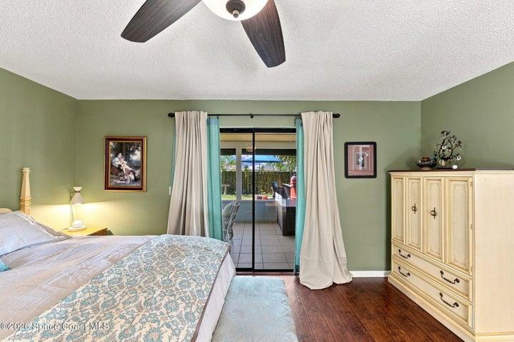Primary bedroom featuring a private en-suite bathroom, large walk-in closet, and direct access to the screened-in lanai.