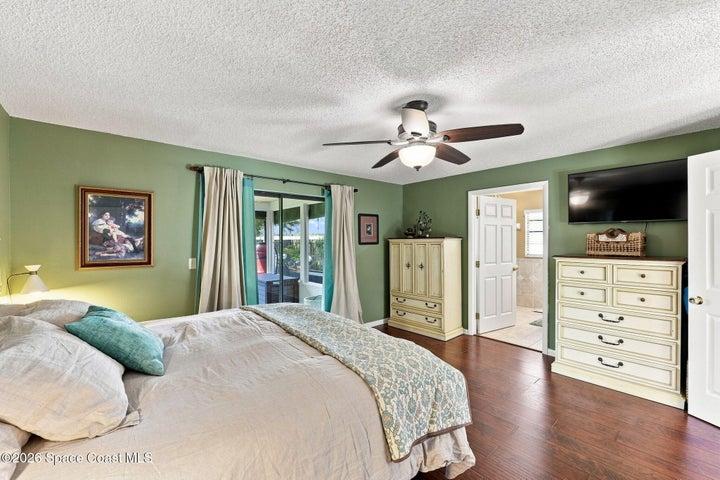 Primary bedroom featuring a private en-suite bathroom, large walk-in closet, and direct access to the screened-in lanai.