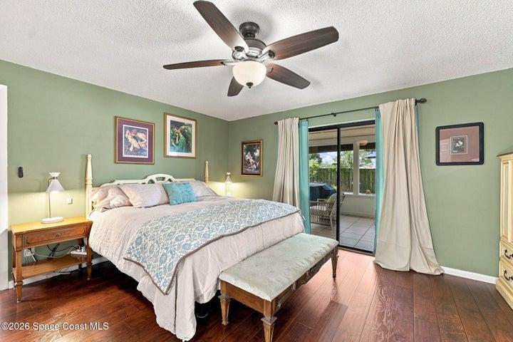 Primary bedroom featuring a private en-suite bathroom, large walk-in closet, and direct access to the screened-in lanai.