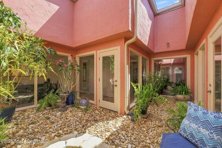 In the heart of the home is the atrium, a serene indoor-outdoor space filled with natural light and surrounded by windows, creating a beautiful connection to nature and bringing the outdoors into the center of the home.
