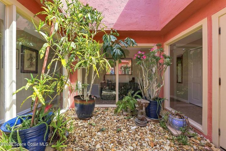 In the heart of the home is the atrium, a serene indoor-outdoor space filled with natural light and surrounded by windows, creating a beautiful connection to nature and bringing the outdoors into the center of the home.