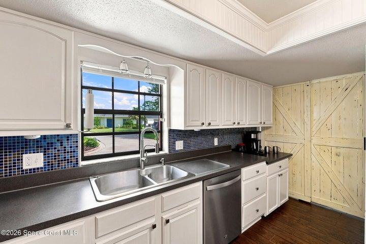 Tucked behind custom barn doors, the dedicated laundry room offers a convenient and functional space just off the kitchen.