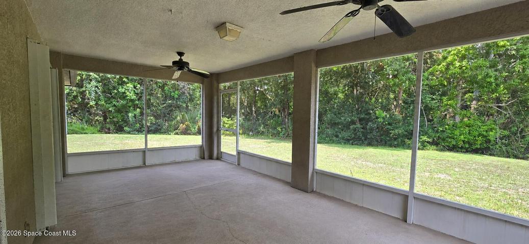 Screened back patio overlooking yard. Digitally decluttered.