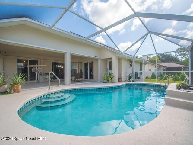 Pool with patio in the background. Bathroom on the right