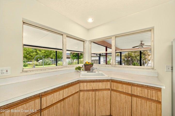 KITCHEN opens to living and dining areas. Looks out to covered lanai and spacious backyard. IMAGINE THE POTENTIAL!
