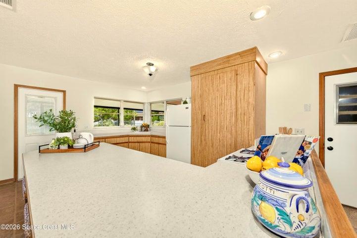 KITCHEN opens to living and dining areas. Looks out to covered lanai and spacious backyard. IMAGINE THE POTENTIAL!