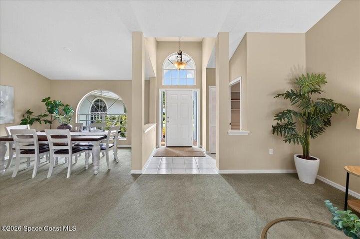 View of front door with formal dining to the left and access to the Primary suite to the right of the front door