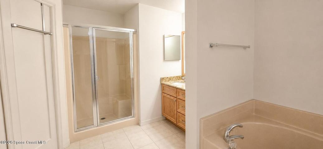 Primary bath with separate shower and tub. Digitally decluttered.