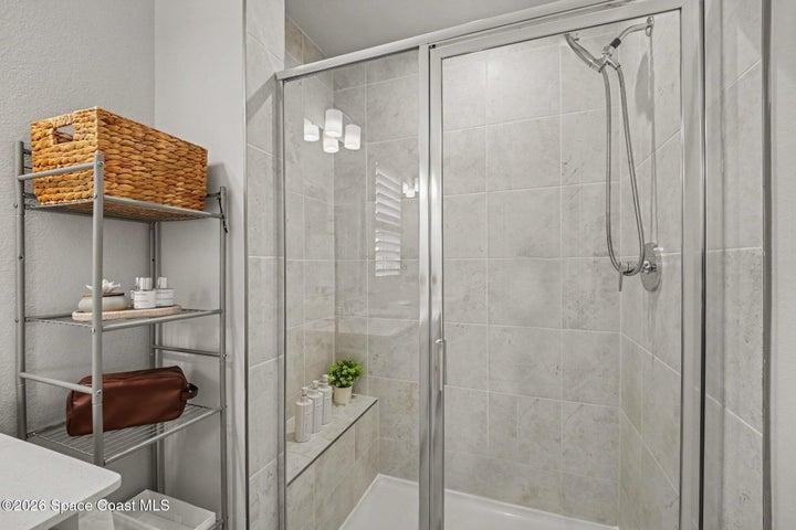 Luxurious walk in shower with 13x13 tile with bench seating.