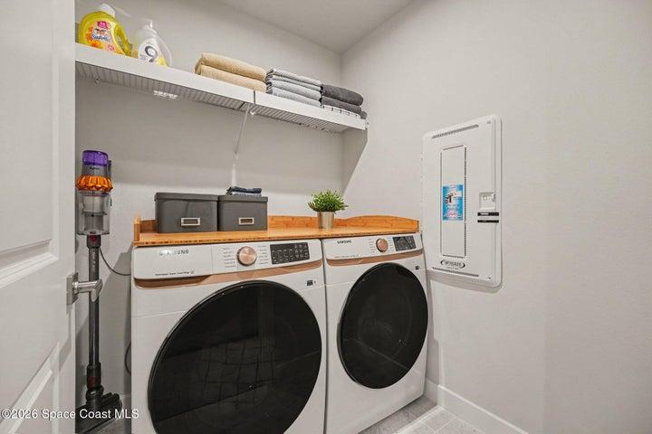 Upstairs walk in laundry room with storage. Top of the line Samsung full size washer & dryer.