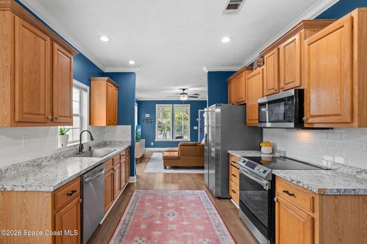 Spacious kitchen featuring abundant cabinetry, granite countertops, stainless steel appliances and an open flow into the main living area.