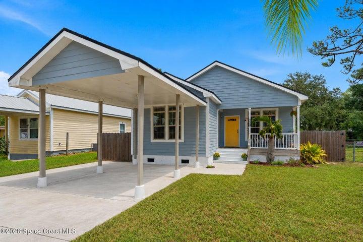 Charming cottage-style home with inviting front porch, cheerful entry and covered carport offering classic Florida curb appeal.