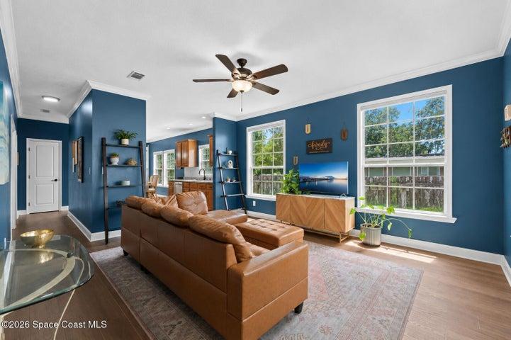 Bright, open living space filled with abundant natural light from oversized windows, creating a warm and inviting atmosphere.