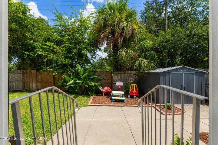 Fenced backyard offers plenty of room for kids to play, with newly placed mulch, mature tropical landscaping, a patio area and storage shed for added convenience.
