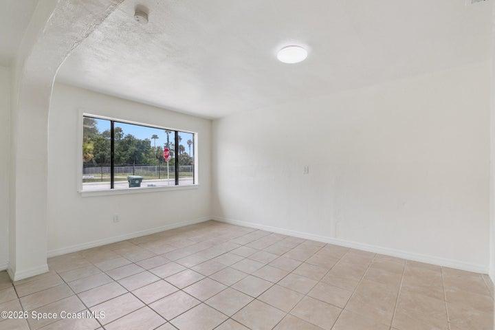 Bright and spacious living area with tile flooring and natural light.
