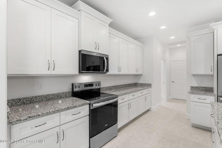 This upgraded home features Granite Countertops, stainless steel appliances, soft close cabinetry, and crown molding.