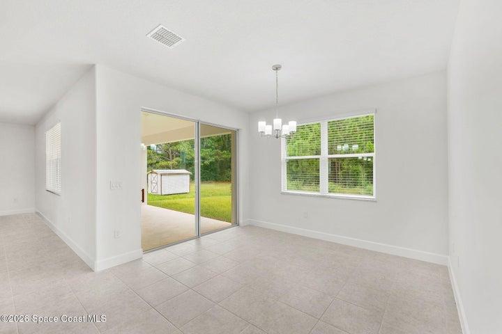 The kitchen nook features a sliding glass door onto the trussed rear porch.