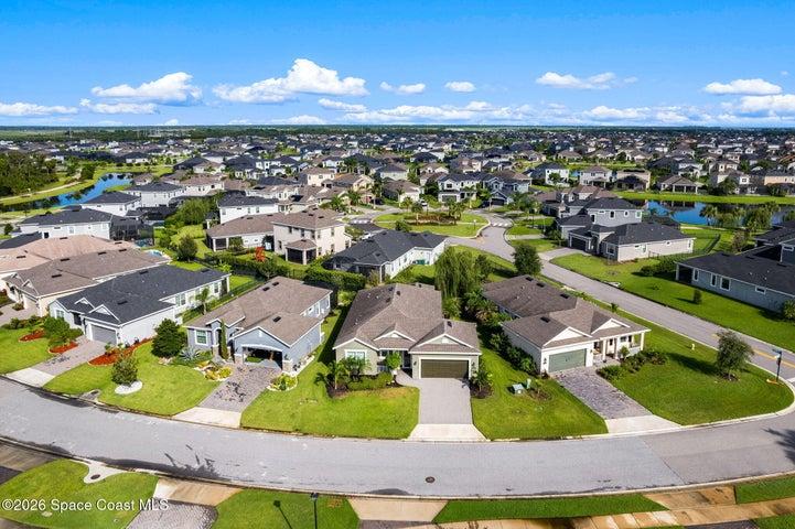 Bird’s-eye view highlighting the home, driveway, and surrounding landscape