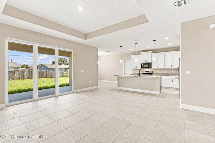 Great Room and Kitchen Combo with oversized sliding glass doors with natural light streaming into the space.