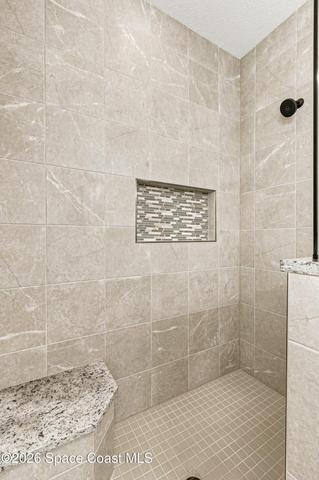 The primary bathroom features a fully tiled walk in shower with an added bench for everyday use.