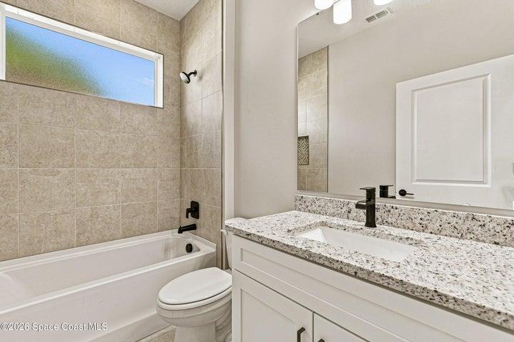 Bathroom 2- Tiled shower with a tub, skylight, and granite countertops.