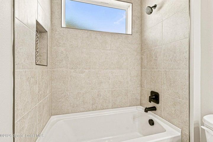 Bathroom 2- Tiled shower with a tub