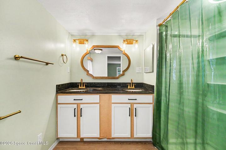 Renovated with Granite Countertops, Dual Sink Vanity, Gold Hardware, & Sconce Light Fixtures.